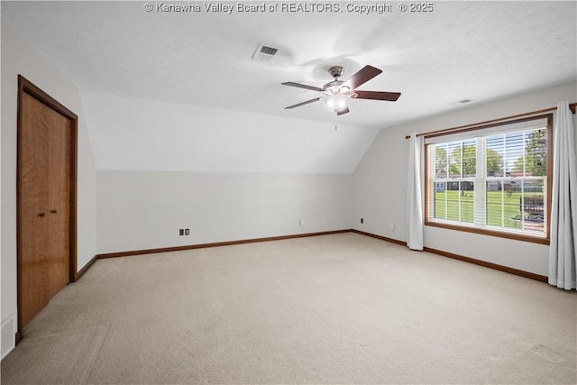 bonus room with visible vents, lofted ceiling, baseboards, ceiling fan, and light colored carpet