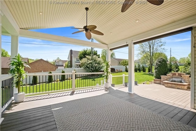 deck with a ceiling fan, fence, and a yard