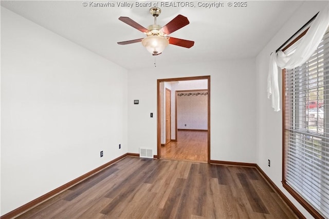 unfurnished room with visible vents, a ceiling fan, baseboards, and wood finished floors