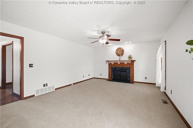 unfurnished living room with ceiling fan, carpet, and visible vents