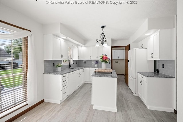 kitchen featuring tasteful backsplash, a healthy amount of sunlight, and a center island