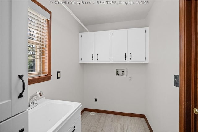 washroom with cabinet space, a sink, hookup for a washing machine, electric dryer hookup, and baseboards