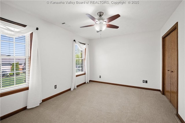 interior space featuring light colored carpet, baseboards, and visible vents