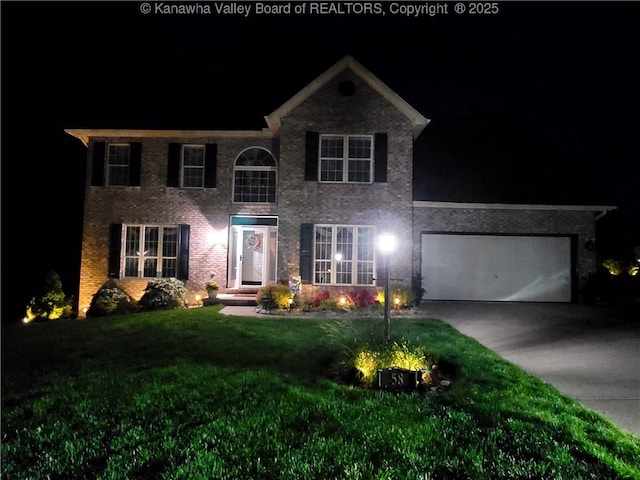 view of front facade featuring concrete driveway, a lawn, an attached garage, and brick siding