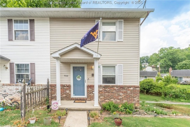 townhome / multi-family property with brick siding and fence