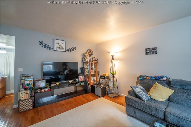 living area with baseboards and wood finished floors