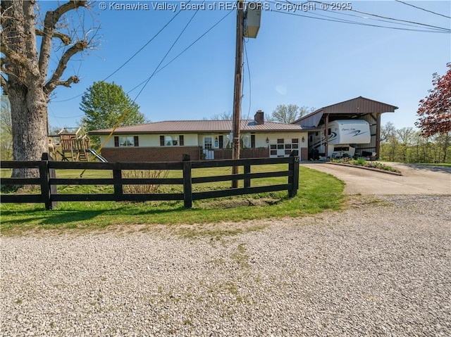 split level home with a carport, a chimney, concrete driveway, and fence private yard