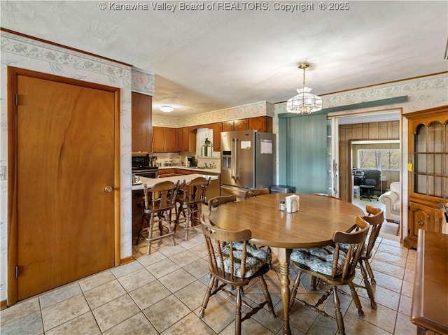 dining room featuring light tile patterned floors, a chandelier, and wallpapered walls