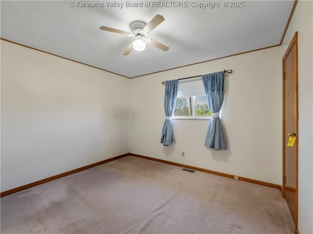 carpeted empty room featuring baseboards, ceiling fan, and visible vents