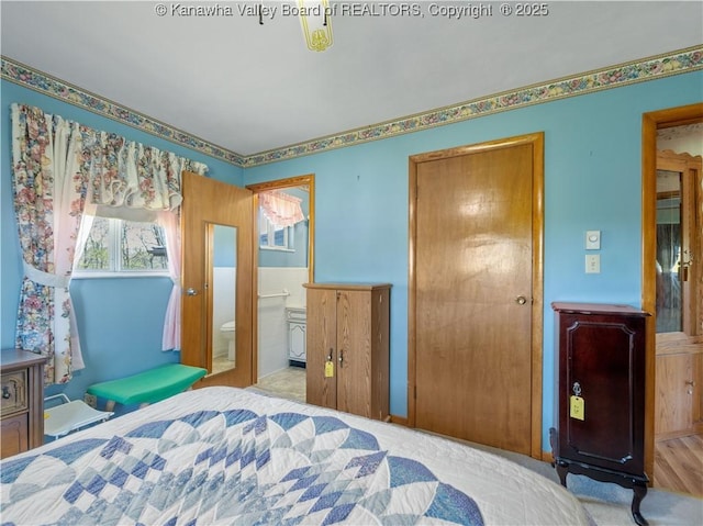 bedroom with carpet flooring and connected bathroom
