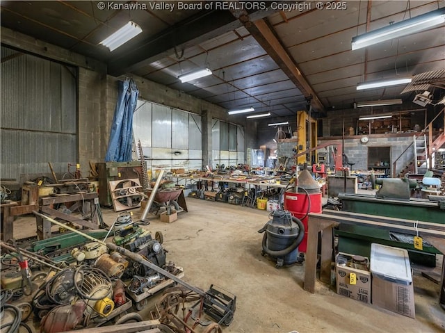 miscellaneous room featuring a workshop area and unfinished concrete flooring