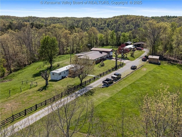 birds eye view of property featuring a rural view and a wooded view