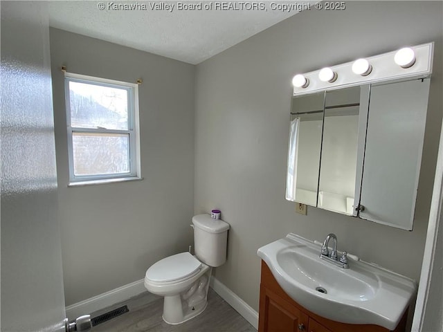 104, 102 1st St, Dunbar, WV 25064 - bathroom featuring visible vents, vanity, wood finished floors, toilet, and baseboards