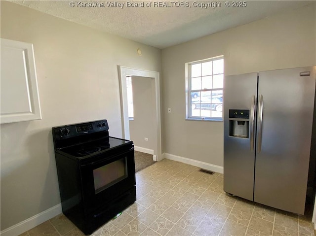 104, 102 1st St, Dunbar, WV 25064 - kitchen featuring electric range, a textured ceiling, visible vents, baseboards, and stainless steel fridge