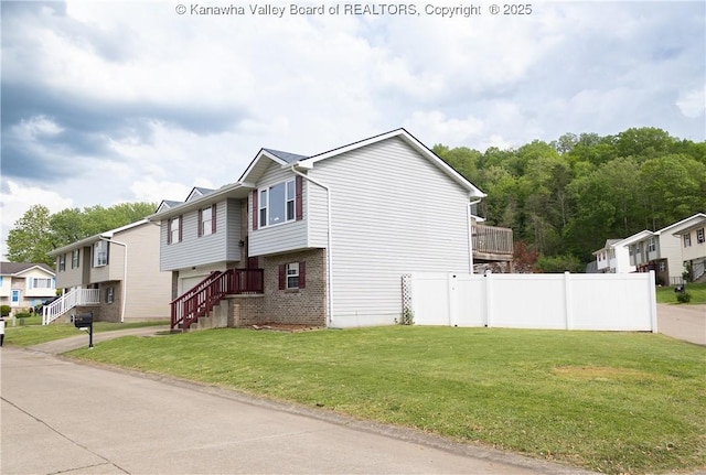 view of home's exterior featuring brick siding, fence, a yard, and a residential view