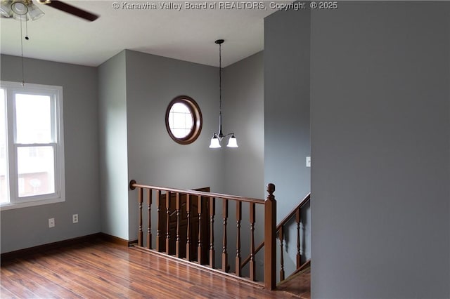 stairs featuring baseboards, a ceiling fan, and wood finished floors