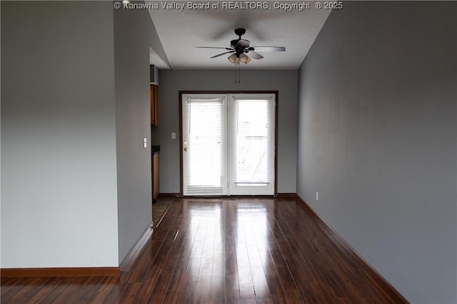 entryway featuring baseboards, dark wood finished floors, and ceiling fan