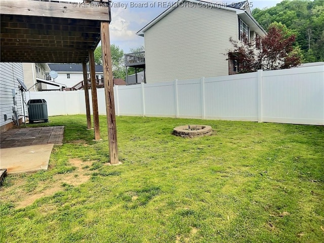view of yard with a patio, central AC, a fire pit, and a fenced backyard