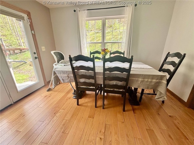 dining space featuring baseboards, a wealth of natural light, and light wood-style flooring