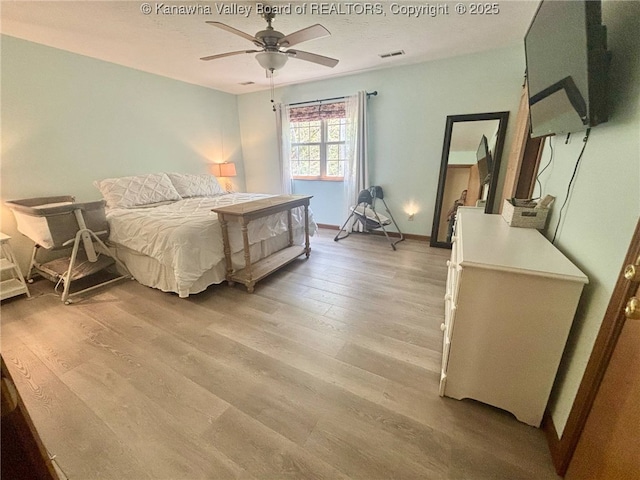 bedroom featuring visible vents, light wood-style flooring, ceiling fan, and baseboards
