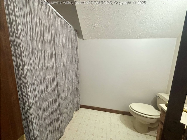 bathroom featuring tile patterned floors, a shower with curtain, toilet, and a textured ceiling