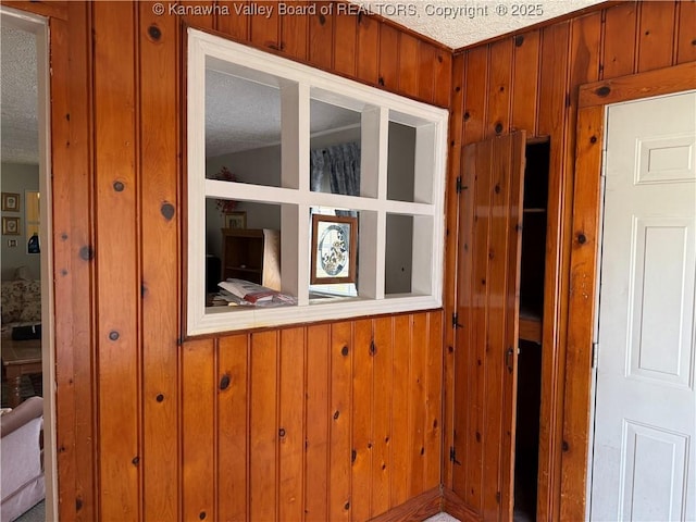interior space featuring wooden walls and a textured ceiling