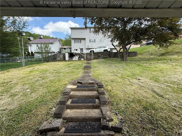 view of yard featuring fence and stairway