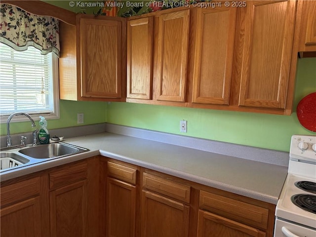 kitchen featuring brown cabinetry, a sink, white range with electric stovetop, and light countertops