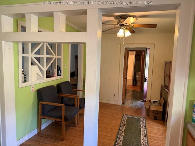 hallway featuring crown molding, baseboards, and wood finished floors
