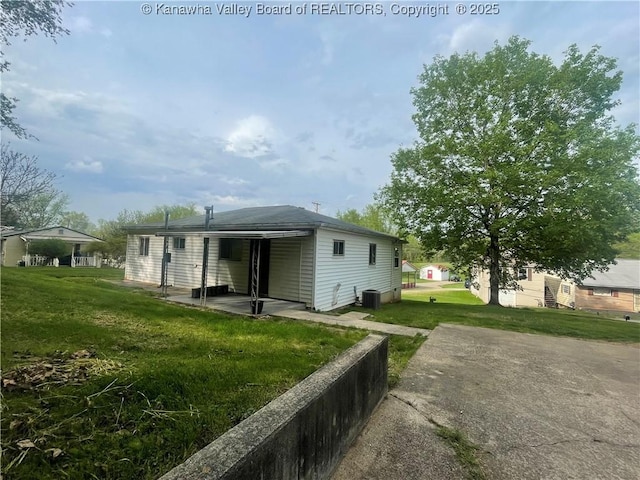 rear view of property featuring a yard and central air condition unit