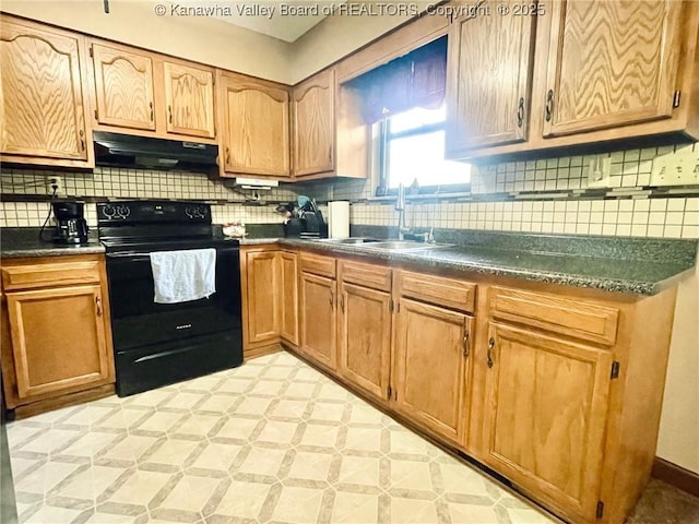 kitchen with decorative backsplash, dark countertops, under cabinet range hood, black electric range, and a sink