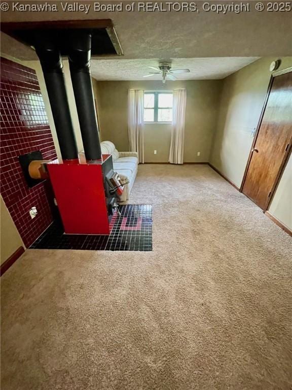 sitting room featuring baseboards, ceiling fan, and carpet