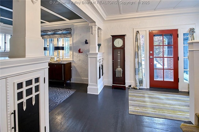 foyer entrance featuring crown molding, dark wood-type flooring, decorative columns, and plenty of natural light