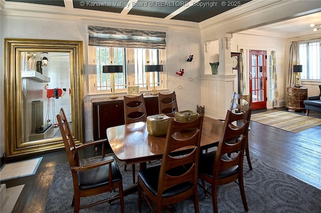 dining area featuring ornate columns, ornamental molding, and wood finished floors
