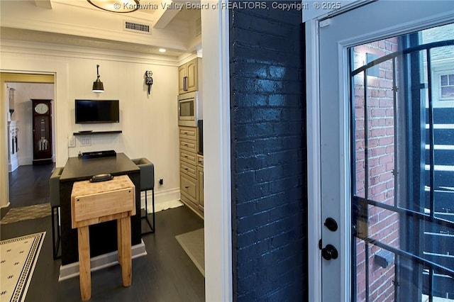 interior space featuring brick wall, visible vents, crown molding, baseboards, and dark wood-type flooring