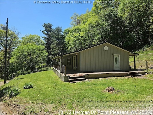 view of property exterior featuring fence, a wooden deck, and a yard