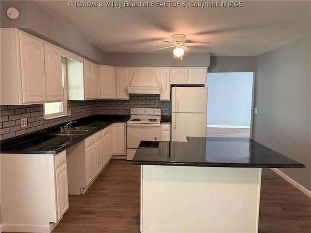 kitchen with a sink, dark countertops, dark wood-style flooring, and white appliances