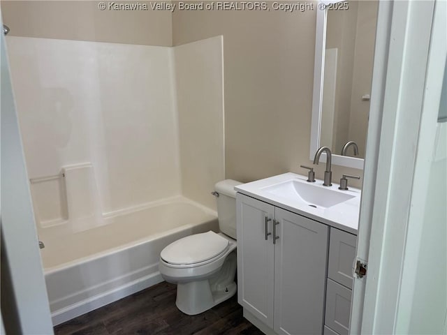 bathroom featuring vanity, toilet, wood finished floors, and shower / tub combination