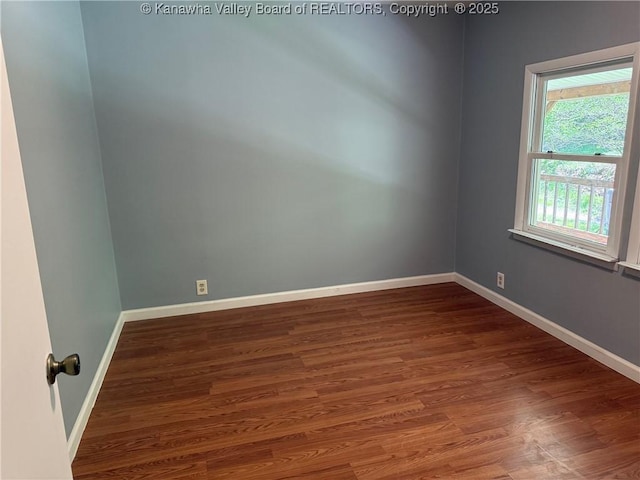 unfurnished room with baseboards and wood finished floors