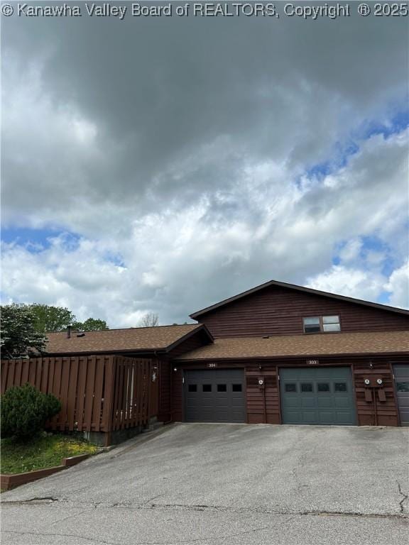 garage with fence and driveway