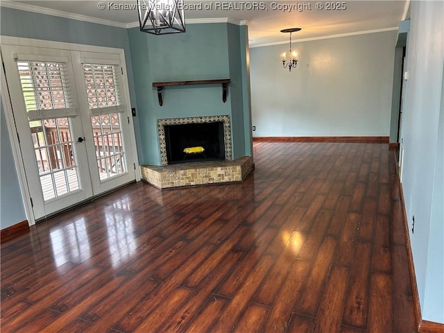 unfurnished living room featuring an inviting chandelier, wood-type flooring, plenty of natural light, and baseboards