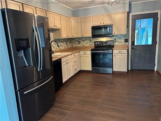 kitchen with light countertops, a sink, black appliances, and tasteful backsplash