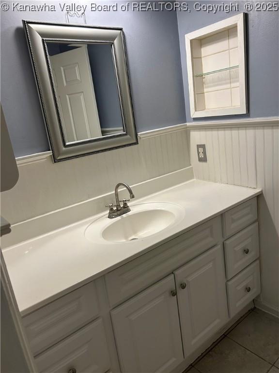 bathroom with wainscoting, tile patterned flooring, and vanity
