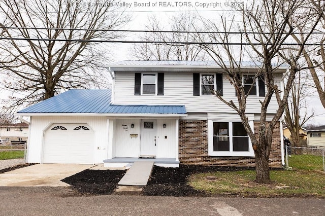 traditional home featuring metal roof, brick siding, fence, concrete driveway, and an attached garage