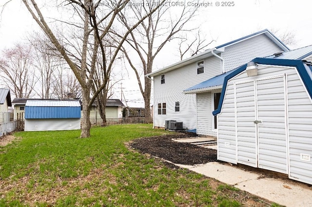 view of yard with a storage shed, fence, an outdoor structure, and central AC
