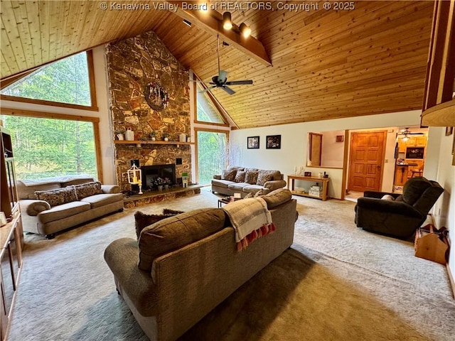 living room with ceiling fan, a stone fireplace, wooden ceiling, high vaulted ceiling, and carpet