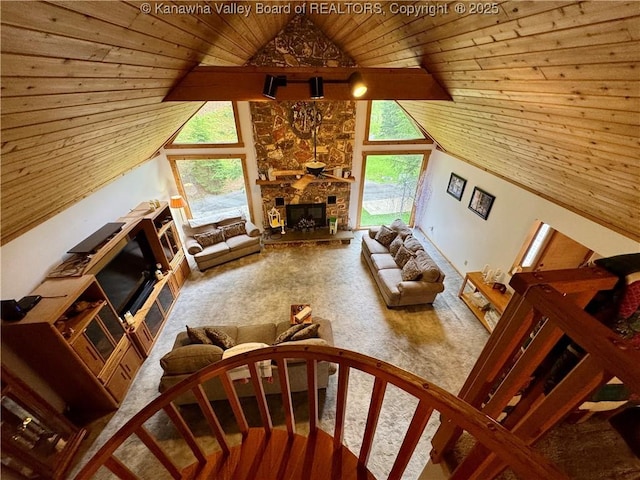 living area with carpet floors, wooden ceiling, a wealth of natural light, and a fireplace