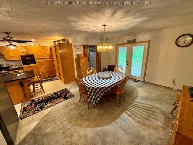 dining area with a textured ceiling, visible vents, french doors, and ceiling fan with notable chandelier