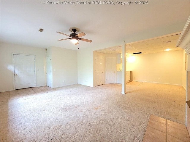 unfurnished living room featuring baseboards, ceiling fan, and light carpet