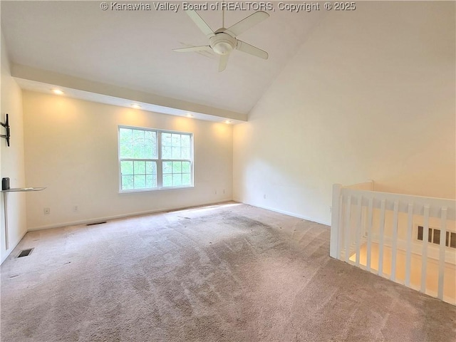 empty room featuring a ceiling fan, visible vents, baseboards, high vaulted ceiling, and carpet